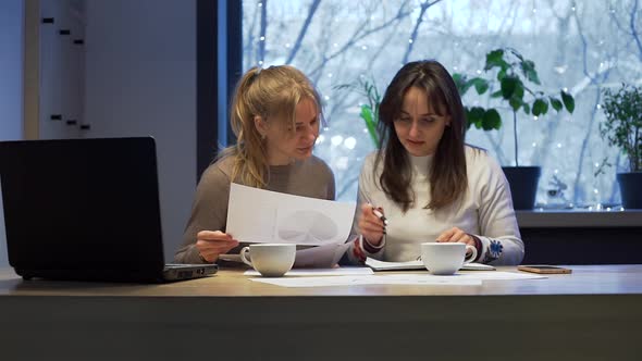 Women Doing Paperwork Together Late at Evening alt