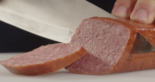 Slicing Meat. With A Sharp Knife Cuts Thin Slices Of Sausage. alt