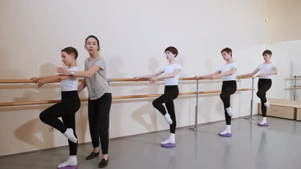 Group of Boys on Ballet Gymnastics Class with Their Teacher Performing Exercise