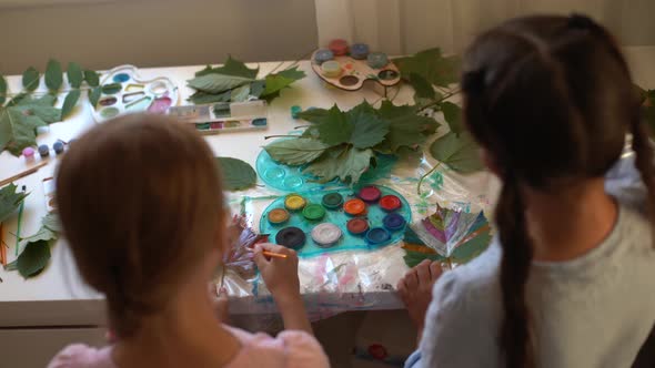 Two Schoolgirls Paint the Leaves