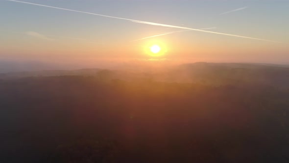 Aerial View of Sunrise Over Foggy Landscape