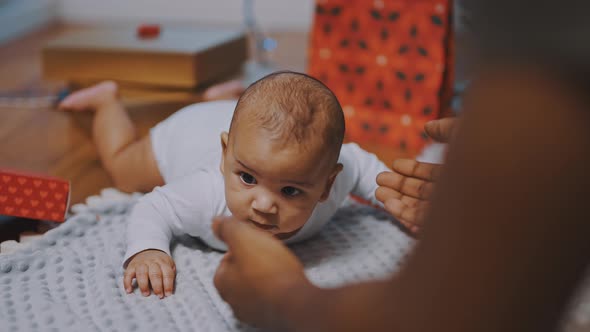 Baby Having Tummy Time Surrounded By Gifts alt