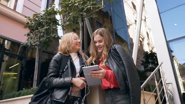 Beautiful Two Female Students Using Tablet Computer Reading Good News alt