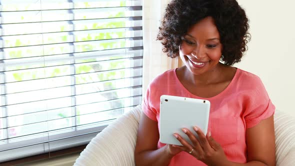 Woman using digital tablet in living room  alt