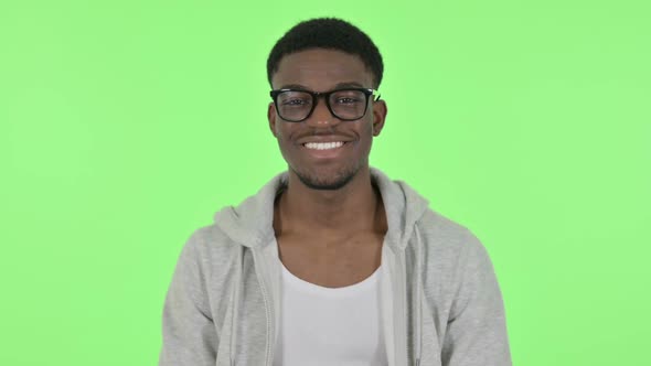African Man Smiling at Camera on Green Background alt