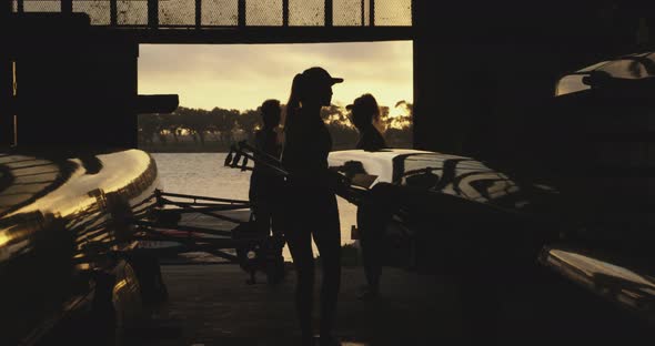 Female rowing team training on a river alt