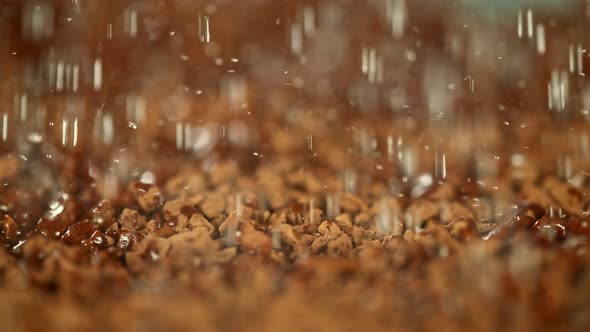 Super Slow Motion Macro Shot of Water Droplets Falling on Instant Coffee at 1000 Fps. alt