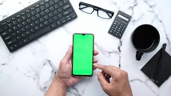 Top View of Man Hand Using Smart Phone on Office Desk  alt