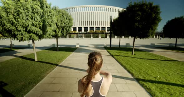 The Girl Looks at Her Watch Before Jogging in the Morning