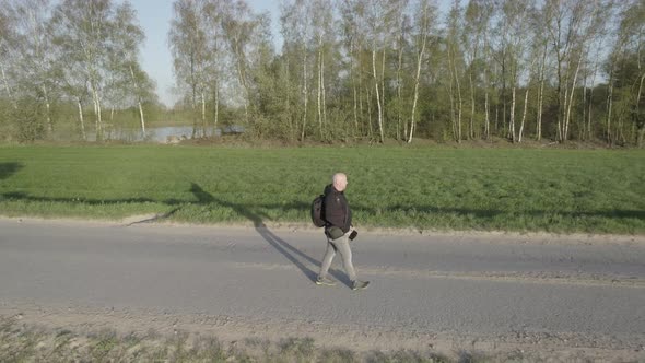 Spectacular Aerial View of a Man Walking in the Wild Countryside Fields During Sunset alt