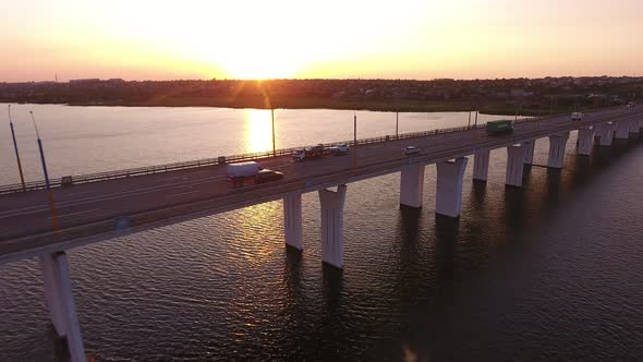 Aerial Shot of a Straight Bridge Over the Dnipro at Golden Sunset in Summer