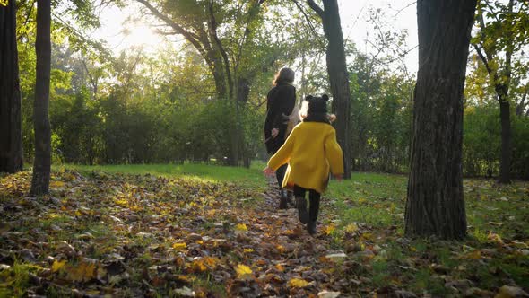 Family Well-being, Young Beautiful Woman Mom Runs with Her Little Beautiful Daughter on Path in alt