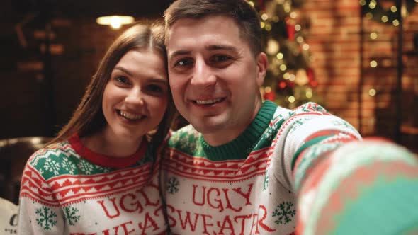 POV Couple at Home With Decorated Christmas Tree Online Video Chatting and Saying Holiday Greetings