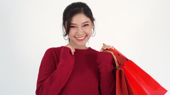 cheerful woman holding red shopping bag