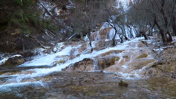 wide shots of water fast streaming over  many shapes  of  yellow stones alt