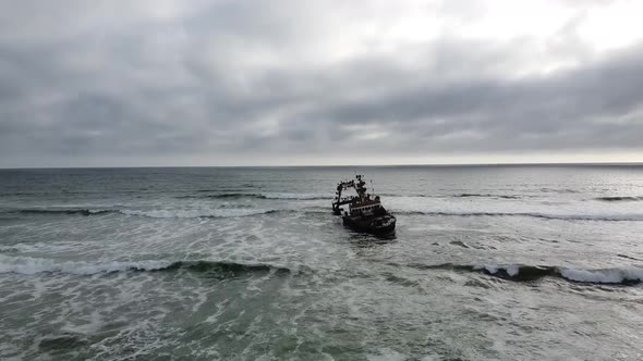Big old sunken ship near the shore, Skeleton Coast in Namibia, cloudy day alt