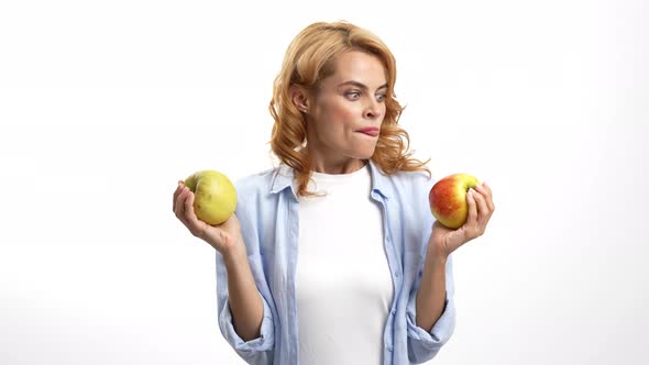 Hungry Woman Choosing Apple Licking Her Lips and Biting Fruit Hunger alt