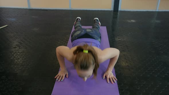 Sports Woman Doing Pushups on Exercise Mat at Gym. 