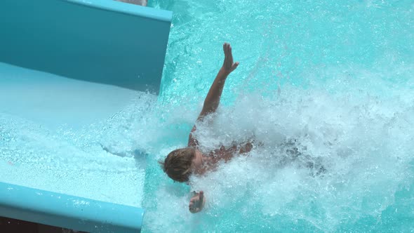 Boy going down waterslide in super slow motion