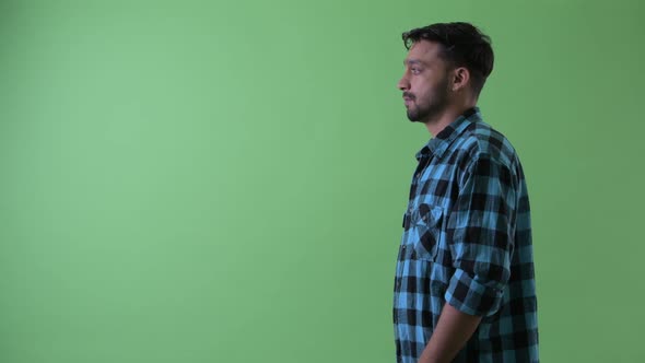 Profile View of Happy Young Bearded Persian Hipster Man Smiling alt