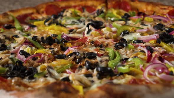 Vegetables cover top of large supreme pizza, close up slider 4K alt