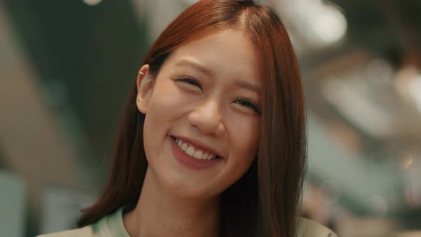 Young Attractive Asian Woman wearing casual clothes looking at the camera and smiling