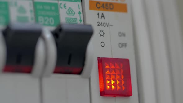 Woman Finger Turns on Electricity Switch and Button Is Lighting alt