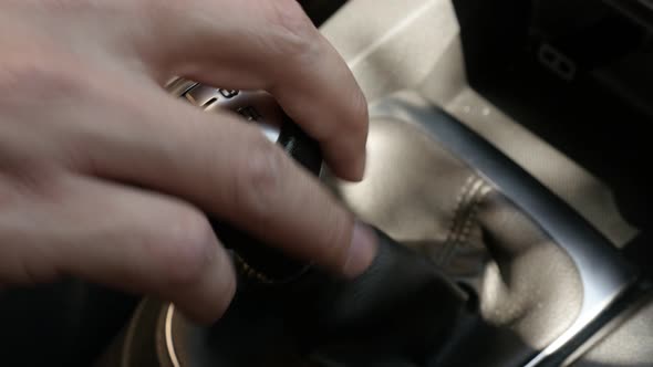 Hand changes gears with car shift stick 4K video alt