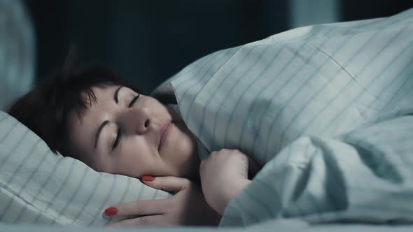 Brunette Woman Puts Her Head on the Pillow at Night and Falls Asleep Cinematic Shot