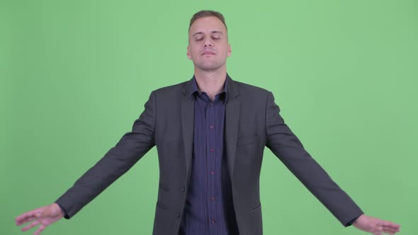 Happy Handsome Businessman in Suit Relaxing with Eyes Closed alt