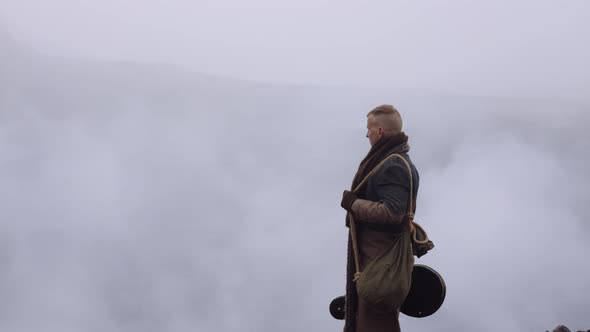 Man In Greatcoat Standing In Misty And Rocky Landscape alt