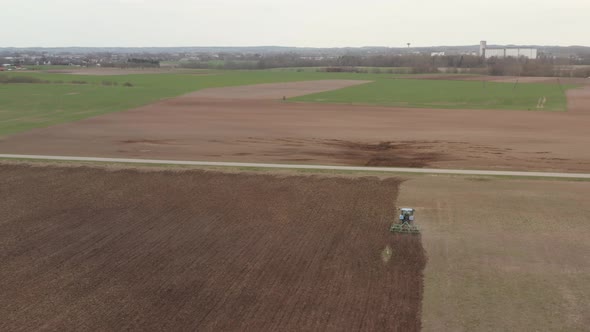 Tractor in the Field Plowing Soil in Spring Season