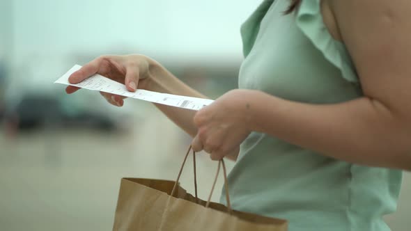 Woman Looking at Cash Receipt After Shopping