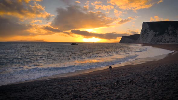 Durdle Door beach on the Jurassic Coast near Lulworth in Dorset, England with colorful dramatic sky. alt