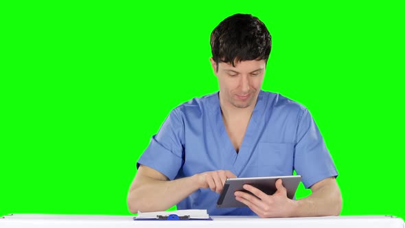 Doctor Uses a Tablet and Shows Thumb. Green Screen alt