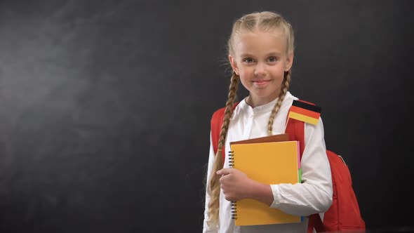 Happy Schoolgirl Holding Books With German Flag Ready to Learn Foreign Language alt