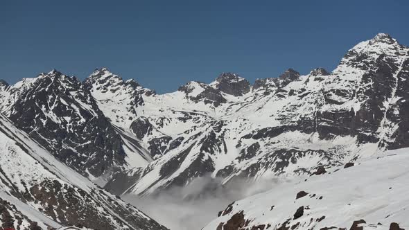 Time lapse shot of low clouds moving through the Andes mountains in Chile alt