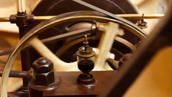 Closeup view of a flywheel of a single cylinder industrial steam engine in operation alt