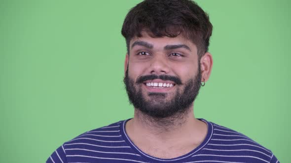 Face of Happy Young Overweight Bearded Indian Man Waving Hand alt