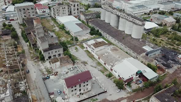 Flying over abandoned industrial factory buildings in very dilapidated condition. alt