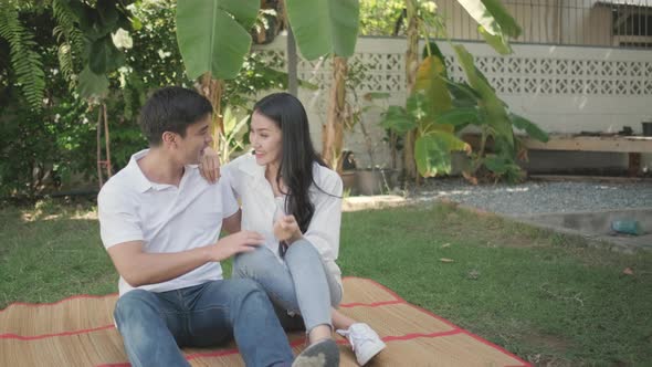 Young mother and father talk together in home garden then their son come to joy with happy