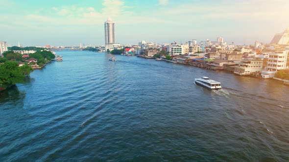 4K UHD : Drones fly over passenger boats moving on the Chao Phraya River alt