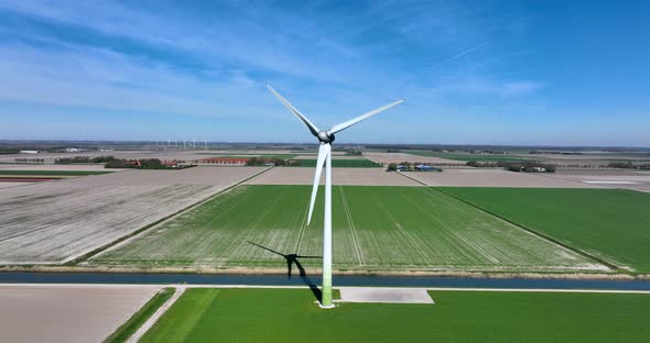 Dutch landscape with typical wind turbines and a water canal. alt