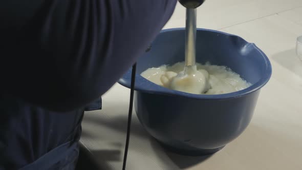 A Confectioner Uses an Immersion Blender to Pierce Hot Custard to Make Eclairs and Croissants alt