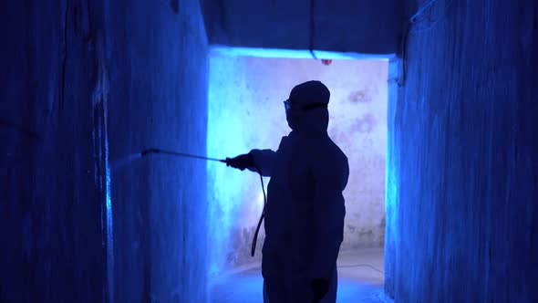 Disinfection against coronavirus COVID-19. Doctor epidemiologist in protective suit sprays medicine. alt