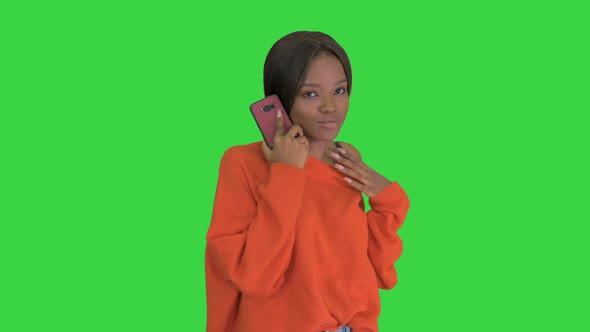 Pretty African American Woman in Bright Jumper Talking on the Phone and Gesturing Emotionally on a alt