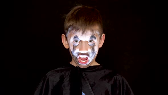 Portrait of a caucasian boy 7-8 years old in a carnival costume with makeup on the face of an evil z alt