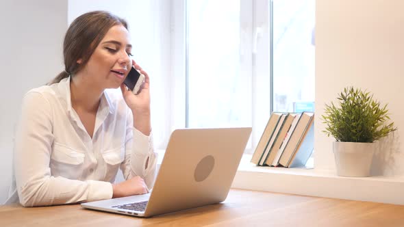 Phone Negotiation by Young Girl, Working on Laptop alt
