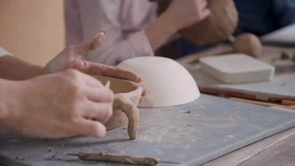 Concentrated Potter Woman Making Earthenware Objects in Studio