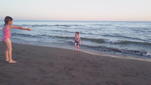 Young Sister and Brother Who Are Playing in the Sea